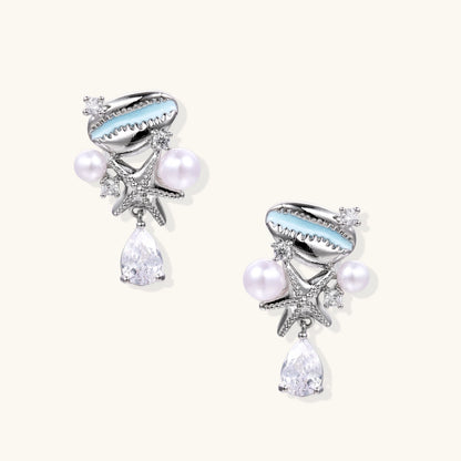 Ocean-themed drop earrings with blue enamel shells, white pearls, starfish charms and crystal teardrops on white background.