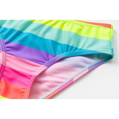 Two-piece rainbow striped girl's swimsuit featuring a golden crown 'Queen' graphic and a pink decorative bow.