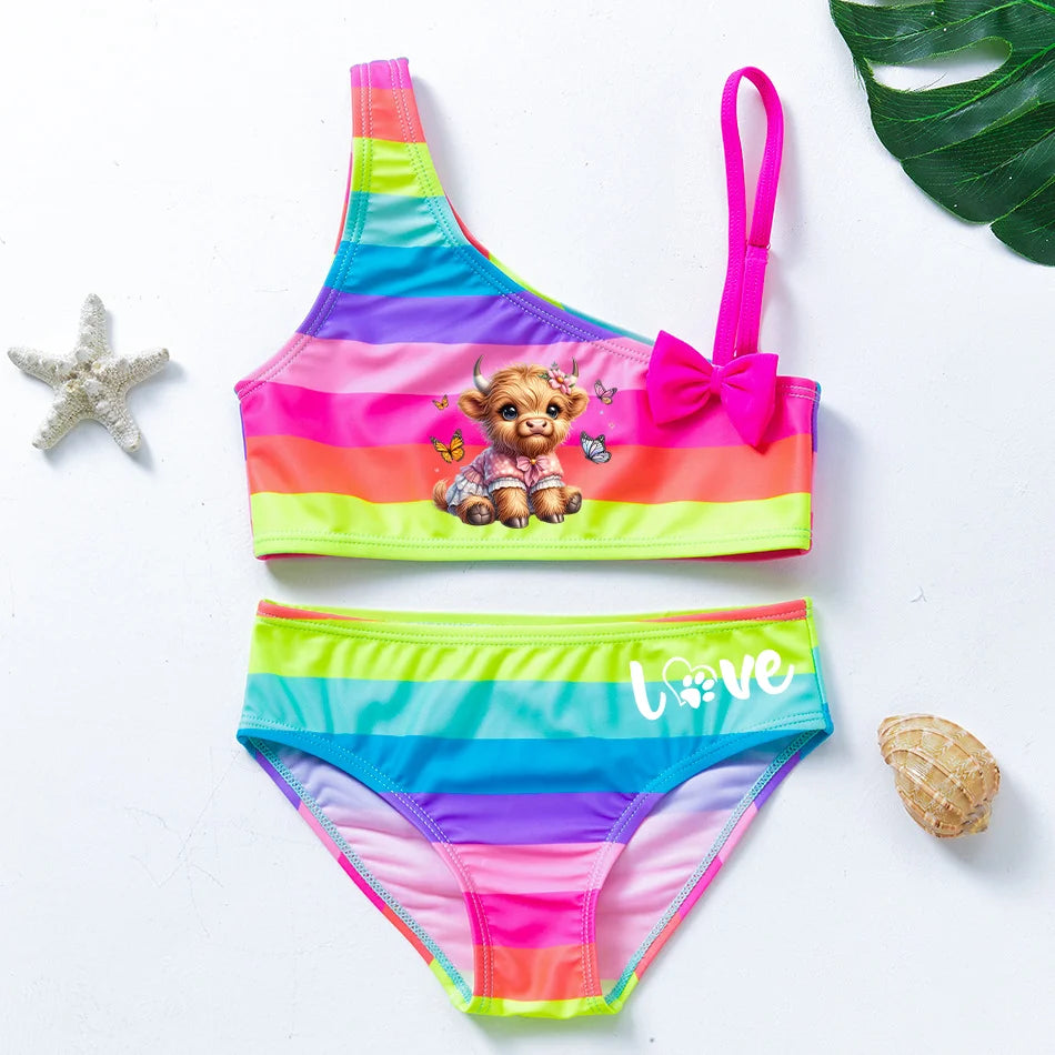 Two-piece rainbow striped girl's swimsuit featuring a golden crown 'Queen' graphic and a pink decorative bow.