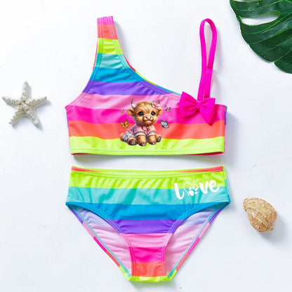 Two-piece rainbow striped girl's swimsuit featuring a golden crown 'Queen' graphic and a pink decorative bow.