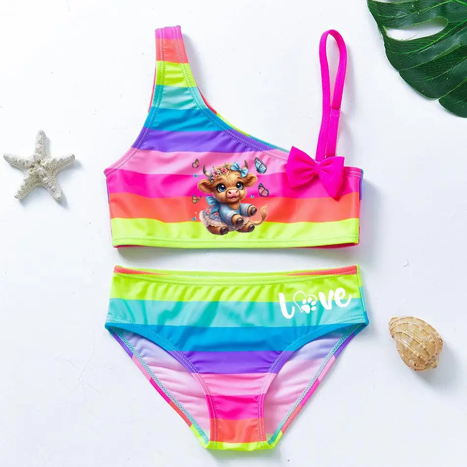 Two-piece rainbow striped girl's swimsuit featuring a golden crown 'Queen' graphic and a pink decorative bow.