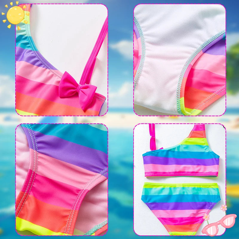 Two-piece rainbow striped girl's swimsuit featuring a golden crown 'Queen' graphic and a pink decorative bow.