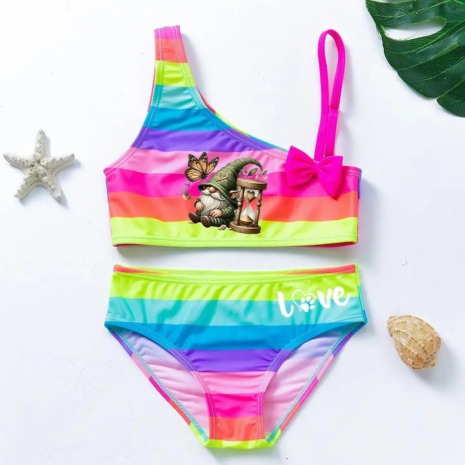 Two-piece rainbow striped girl's swimsuit featuring a golden crown 'Queen' graphic and a pink decorative bow.