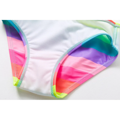 Two-piece rainbow striped girl's swimsuit featuring a golden crown 'Queen' graphic and a pink decorative bow.