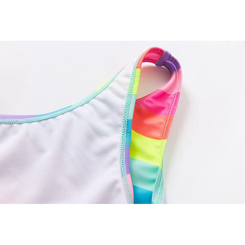 Two-piece rainbow striped girl's swimsuit featuring a golden crown 'Queen' graphic and a pink decorative bow.