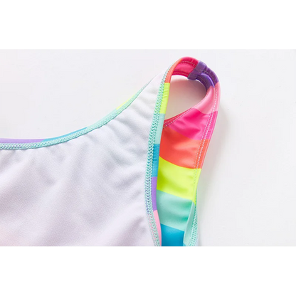 Two-piece rainbow striped girl's swimsuit featuring a golden crown 'Queen' graphic and a pink decorative bow.