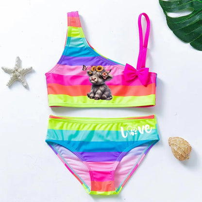 Two-piece rainbow striped girl's swimsuit featuring a golden crown 'Queen' graphic and a pink decorative bow.