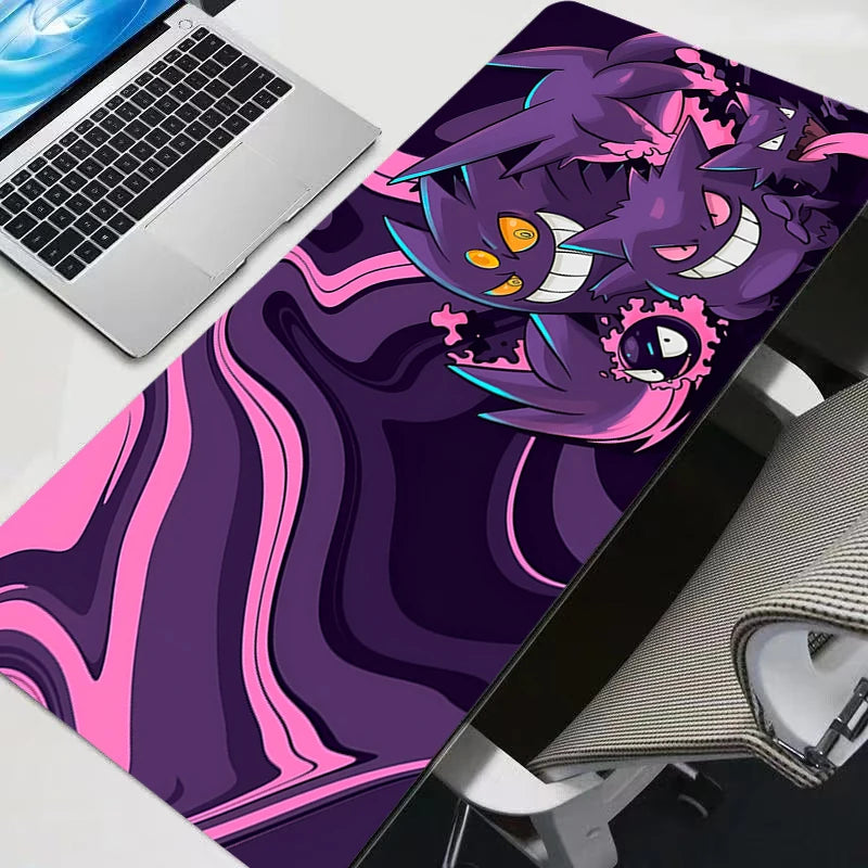 Psychadelic purple and pink Gengar XXL gaming mouse pad on a modern desk setup with a laptop.