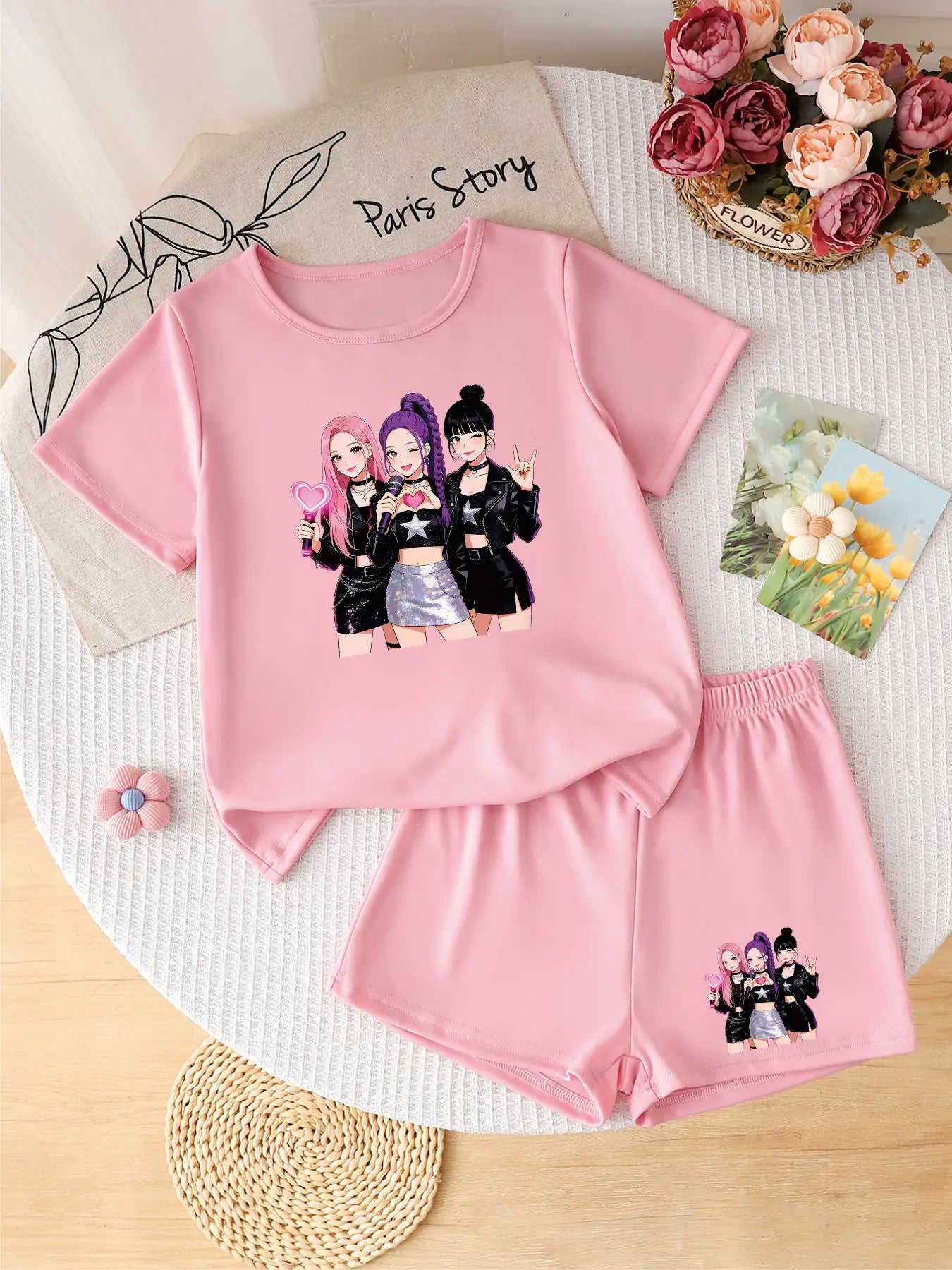 Flatlay of a trendy pink 2-piece girls' outfit featuring a K-POP idol group graphic on the t-shirt and shorts.
