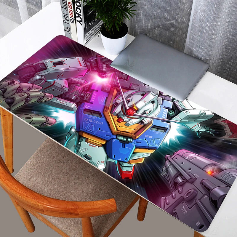 Action-packed Gundam RX-78-2 XXL gaming mouse pad on a white desk setup next to a laptop.