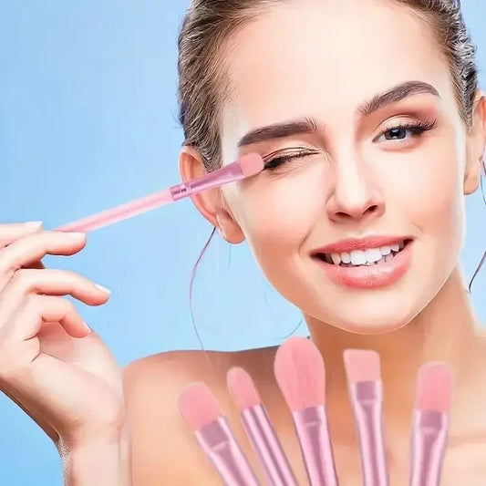 Woman applying eyeshadow with a soft pink synthetic brush from the 13-piece premium set.