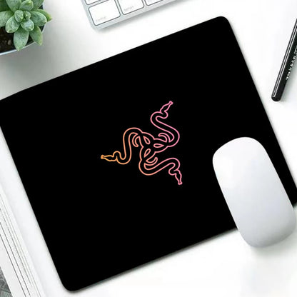Razer luxury mouse pad with a sunset orange and pink gradient logo on a clean white desk setup.