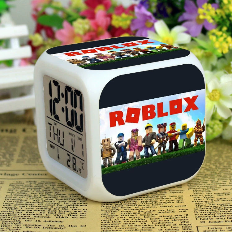Square Roblox LED digital alarm clock with color-changing light and gaming character graphics, available at Dobermen Premier.