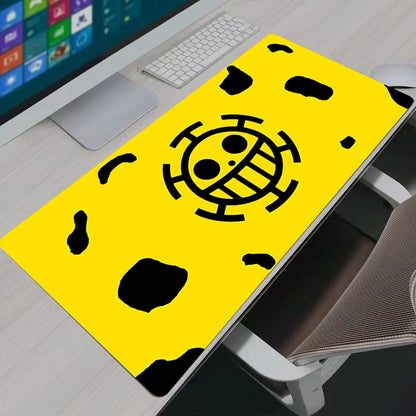 Trafalgar Law Heart Pirates themed yellow and black XXL gaming mouse pad on a modern desk setup.