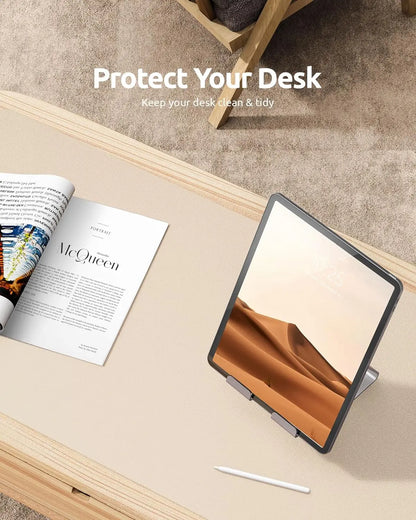 Cream-colored YSAGi leather desk mat protecting a wooden desk with an iPad and a fashion magazine.